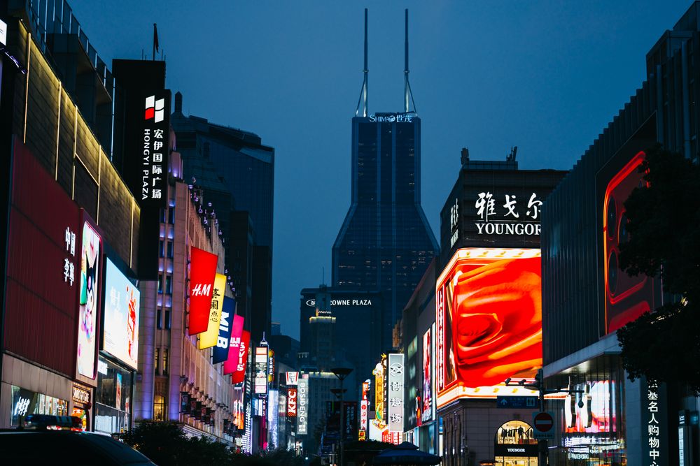 Illuminated signs along a Shanghai shopping street at blue hour
